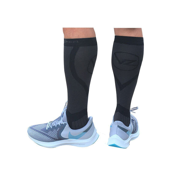 black compression socks vin zen with subtle grey design on a mans leg wearing nike shoes